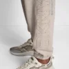 Pantalones Jogger con logotipo de pedrería y contorno bordado en relieve